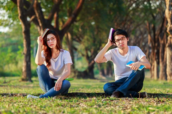 Man and woman sitting and reading a book in park — Stock Photo, Image