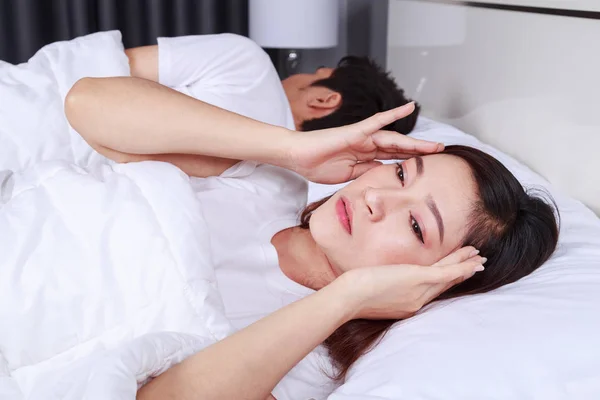 Kvinna att ha sömnlösa på säng och med migrän, stress, insomn — Stockfoto