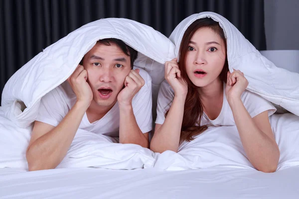 Pasangan menonton film takut di bawah selimut di tempat tidur — Stok Foto