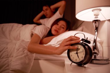 çalar saat m uykulu çift yatakta uzanan ile el