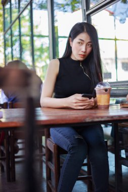 Kafede akıllı telefon kullanan kadın.