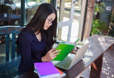 laptop bir kitap okuma ve çalışma kadın