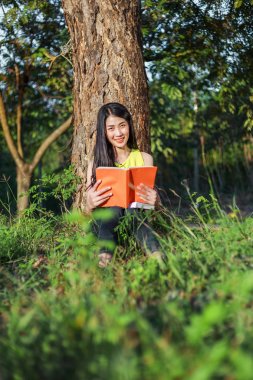oturma ve parkta bir kitap okuma kadın