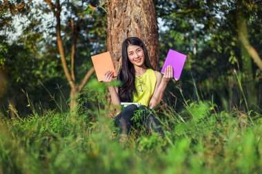 oturma ve parkta bir kitap tutan kadın