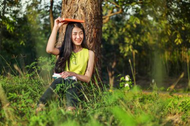 oturma ve parkta bir kitap tutan kadın