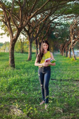 parkta bir kitapla tutan kadın