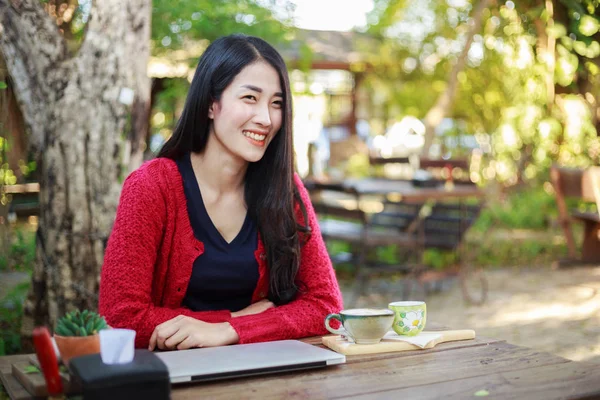 ノート パソコン、ガーデンでのコーヒーを持つ若い女性の肖像画 — ストック写真