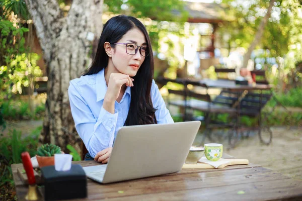 Portrait de jeune femme avec ordinateur portable et café dans le jardin — Photo