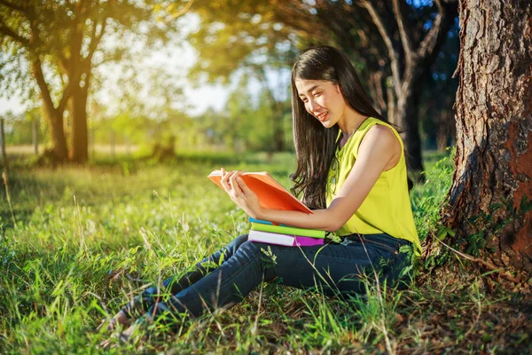 Kvinna sitter och läser en bok i parken — Stockfoto