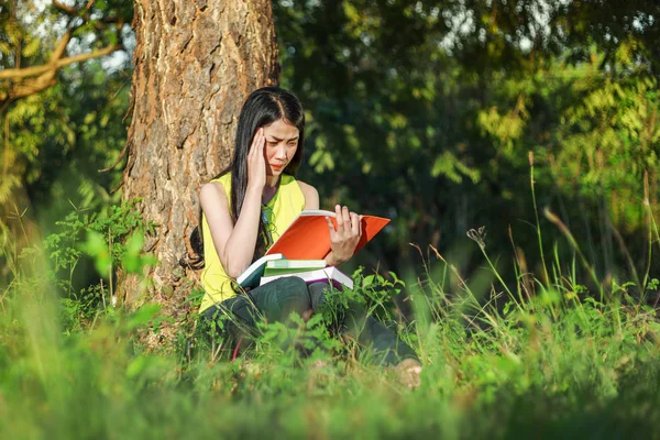 Kvinnan i stressituation när man läser en bok i parken — Stockfoto