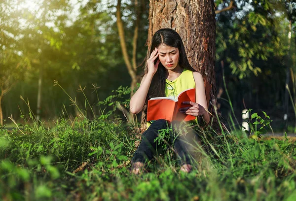 Kvinnan i stressituation när man läser en bok i parken — Stockfoto
