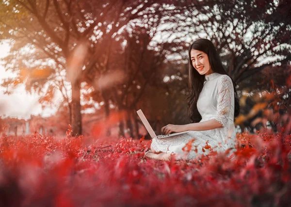 Vacker kvinna med laptop i parken — Stockfoto