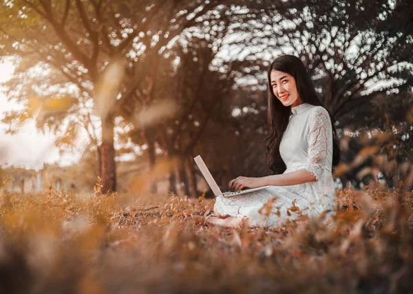 Vacker kvinna med laptop i parken — Stockfoto