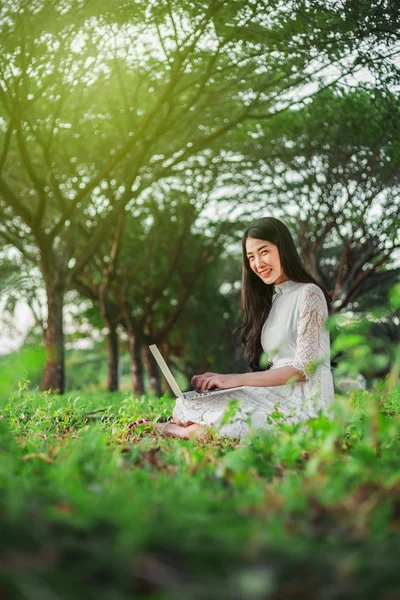 Schöne Frau mit Laptop im Park — Stockfoto