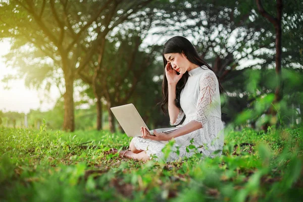 Használ a laptop, a park, a gyönyörű nő — Stock Fotó