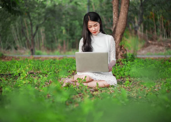 Όμορφη γυναίκα που χρησιμοποιούν φορητό υπολογιστή στο πάρκο — Φωτογραφία Αρχείου