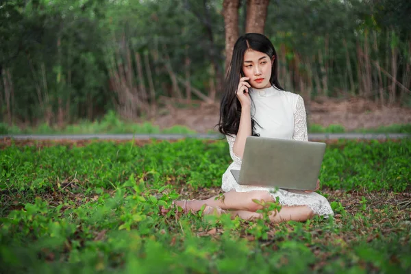 Vacker kvinna med laptop och ringa med mobiltelefon i th — Stockfoto