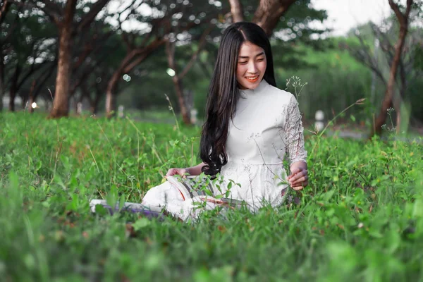 Een vrouw die een boek leest in het park — Stockfoto