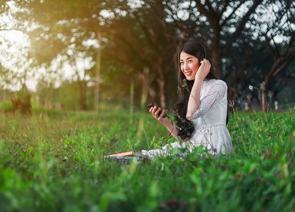 Kvinna med hörlurar Lyssna på musik från smart telefon och si — Stockfoto