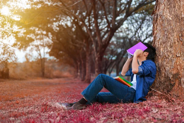 Ung man i stressituation när man läser en bok i parken — Stockfoto