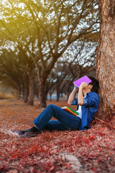 Ung man i stressituation när man läser en bok i parken — Stockfoto