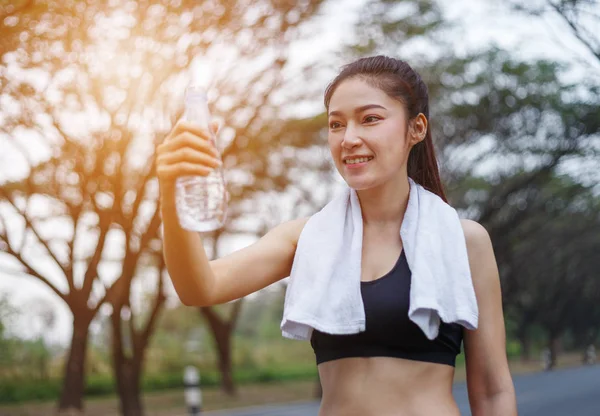 Jeune femme sportive avec bouteille d'eau dans le parc — Photo