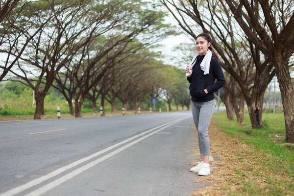 Joven mujer deportiva con toalla blanca descansando después del deporte de entrenamiento — Foto de Stock