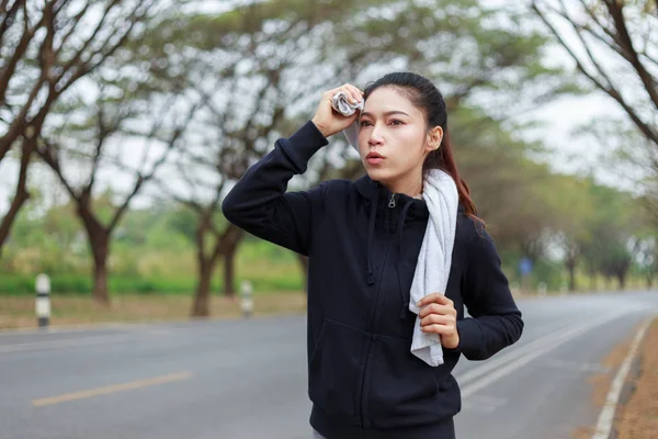 Jeune femme sportive courir et essuyer sa sueur avec une serviette dans — Photo