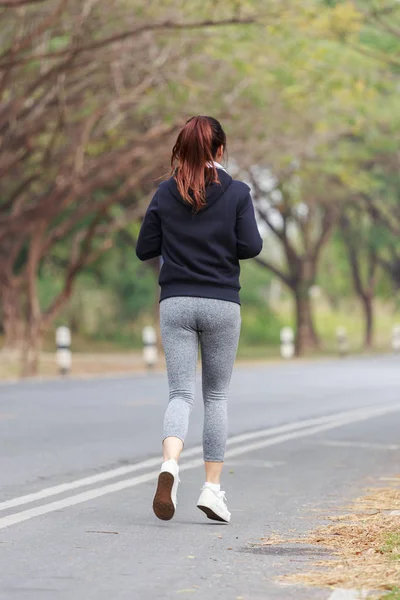 Jeune femme fitness courir dans le parc — Photo