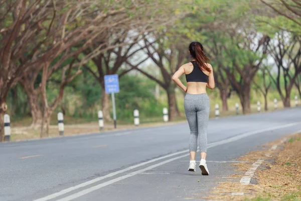 Νέοι γυμναστήριο γυναίκα που τρέχει στο πάρκο — Φωτογραφία Αρχείου