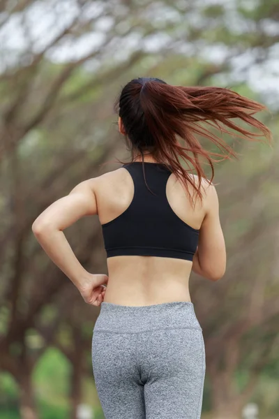 Jeune femme fitness courir dans le parc — Photo