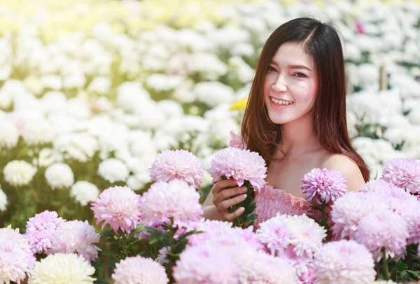 Красива жінка в глянцевому саду хризантем — стокове фото