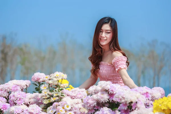 Beautiful woman in chrysanthemum glower garden — Stock Photo, Image