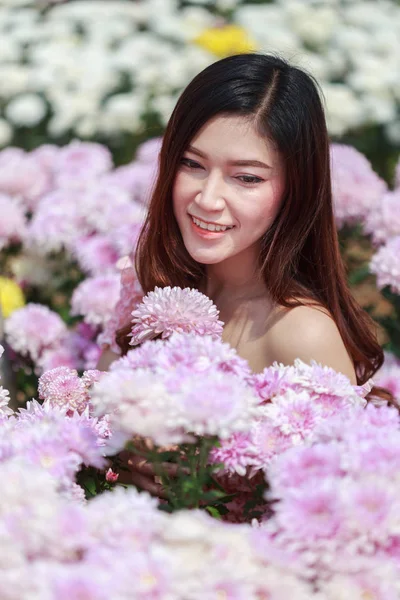 Beautiful woman in chrysanthemum glower garden — Stock Photo, Image