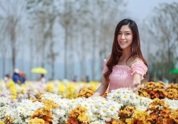 Hermosa mujer en el jardín brillante crisantemo — Foto de Stock