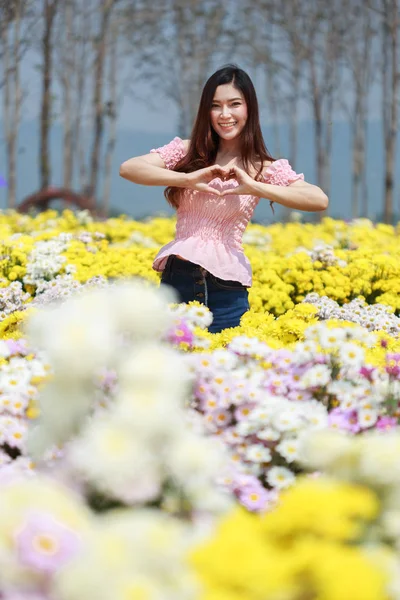 Beautiful woman in chrysanthemum glower garden — Stock Photo, Image