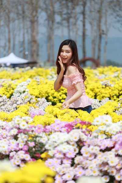 Beautiful woman in chrysanthemum glower garden — Stock Photo, Image
