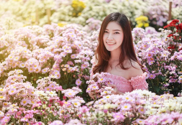 Hermosa mujer en el jardín brillante crisantemo — Foto de Stock