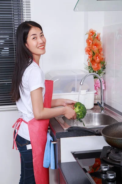 Mujer lavando brócoli bajo el agua corriente en el fregadero de la cocina —  Fotos de Stock