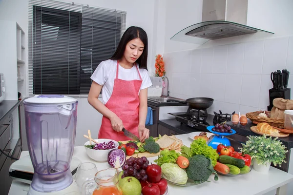 Женщина, использующая нож для резки брокколи в кухне — стоковое фото