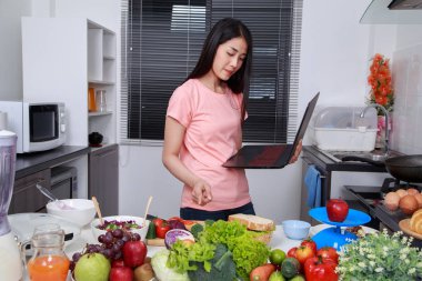 yemek ve mutfak oda içinde laptop ile arayan kadın
