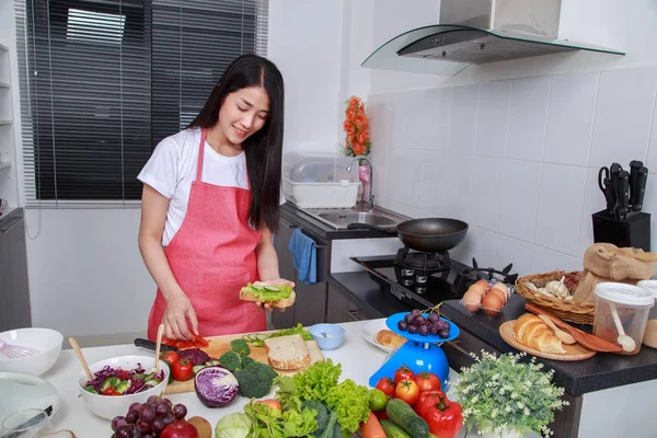 Donna che prepara un panino in cucina — Foto Stock