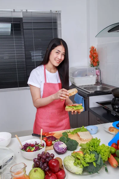 Женщина готовит сэндвич в кухне — стоковое фото