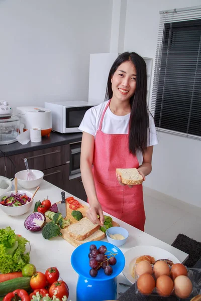 Mulher preparando um sanduíche na sala de cozinha — Fotografia de Stock