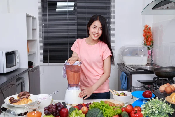 Donna che fa frullati di verdure con frullatore in cucina — Foto Stock