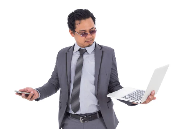 Homem de negócios segurando telefone celular e laptop isolado no branco b — Fotografia de Stock