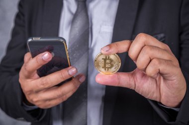 iş adamı bitcoin ve cep telefonu kullanarak kapatın