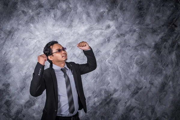 Hombre de negocios ganador en traje con los brazos levantados — Foto de Stock