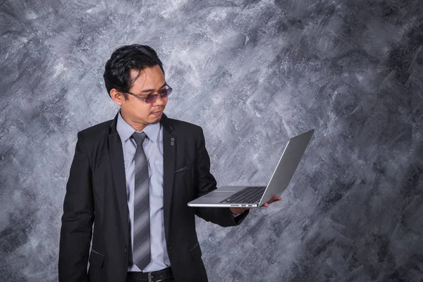 Jeune homme d'affaires tenant ordinateur portable — Photo