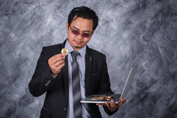 Homme d'affaires tenant Bitcoin or avec ordinateur portable — Photo
